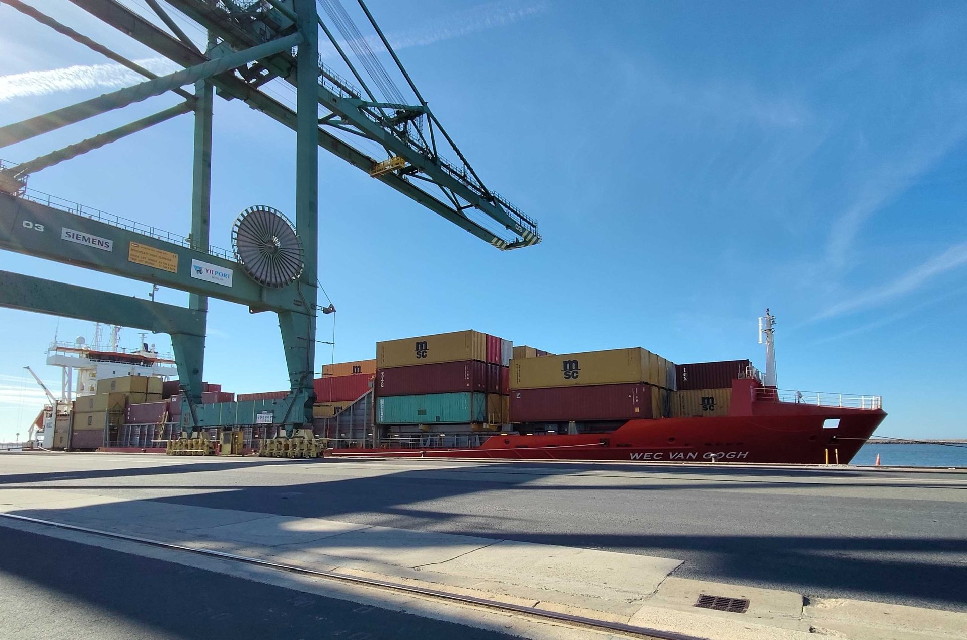 Buque portacontenedores "WEC Van Gogh" atracado en el Muelle Sur del Puerto de Huelva, bajo las grúas de la terminal.
